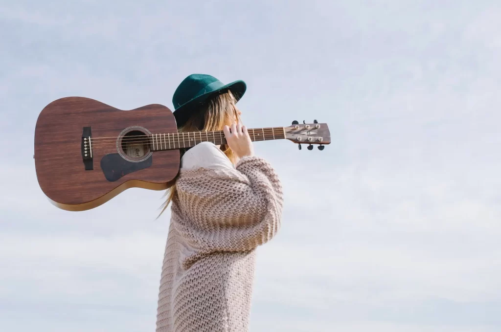 Žena sa gitarom. Simbolizuje kako da postinemo flow stanje u hobijima.